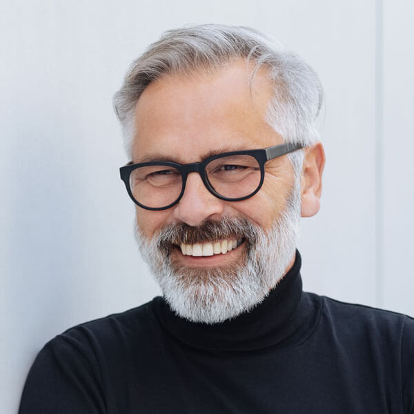 relaxed senior man with beard and glasses