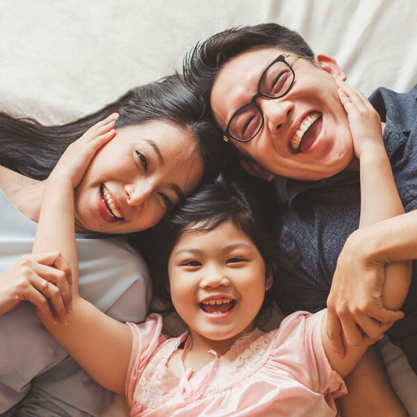 happy family laying on bed